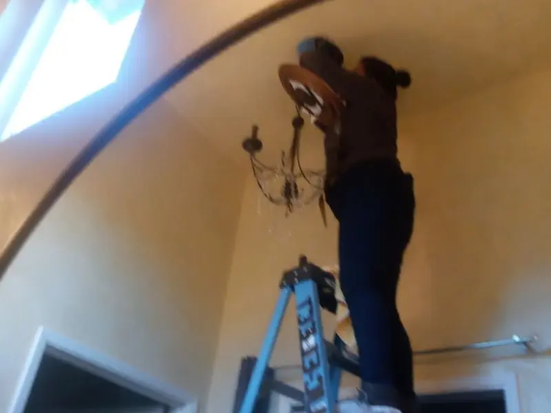 Electrician installing a chandelier in a Eastover residence
